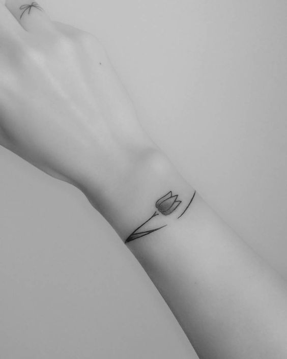 A minimalist black-line tulip tattoo on the wrist, featuring a simple geometric design with clean lines for a delicate and elegant look.