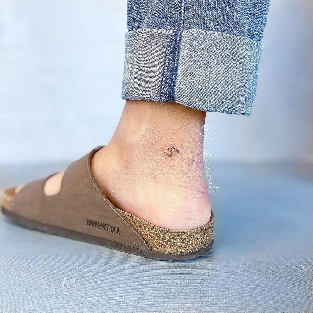 Ankle with an Om tattoo, a reminder to breathe in tranquility