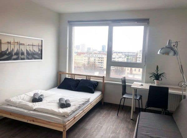 Simple and bright studio with a functional desk and city view.