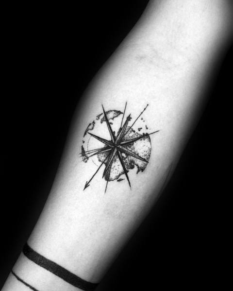 Minimalist compass tattoo with fine-line detailing and a world map overlay, symbolizing exploration and adventure in a sleek design.