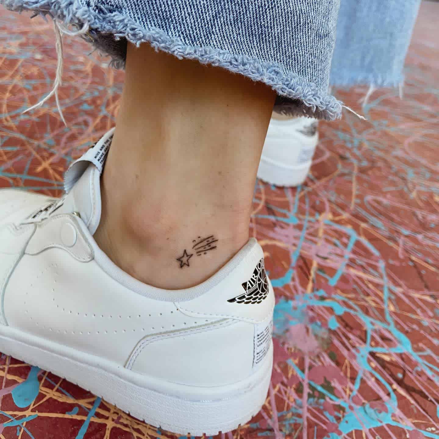 Minimalist tattoo featuring a tiny star and shooting stars