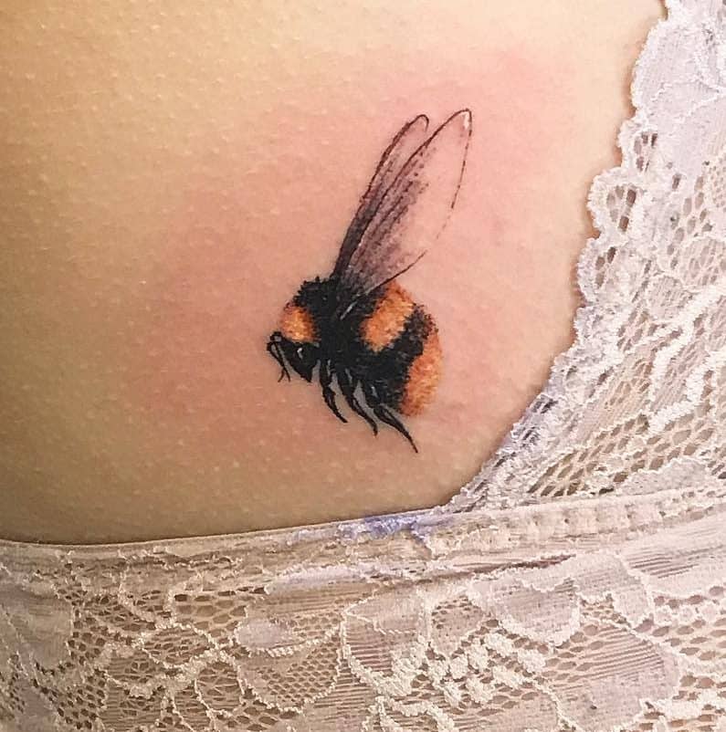 Realistic bumblebee tattoo with delicate wings and fuzzy black-and-orange details