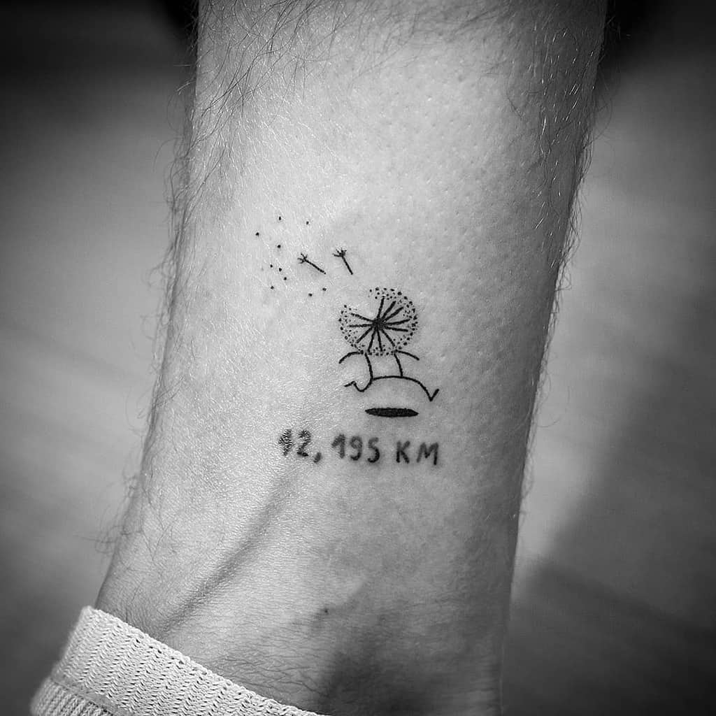 Minimalist dandelion tattoo with a running figure and '42.195 KM' text, symbolizing endurance, perseverance, and the marathon journey.