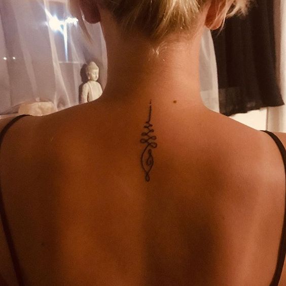 Unalome tattoo on the upper back, symbolizing spiritual growth, enlightenment, and the journey toward inner peace.