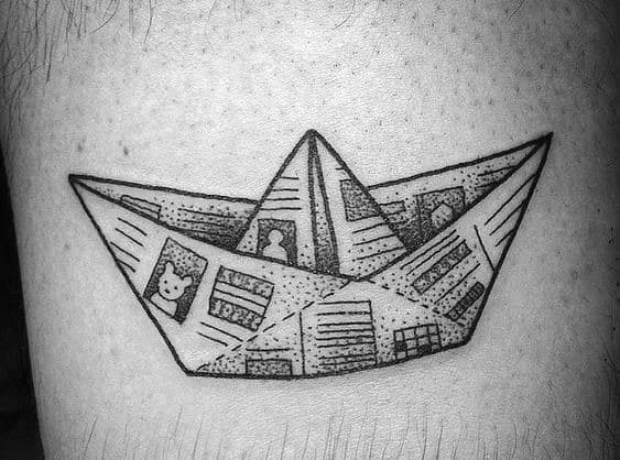 Detailed black ink tattoo of a paper boat made from newspaper, symbolizing storytelling, nostalgia, and life's journey.
