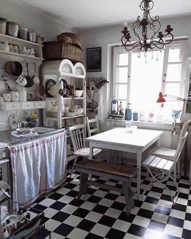 white rustic kitchen white wood table black and white tile floor chandelier