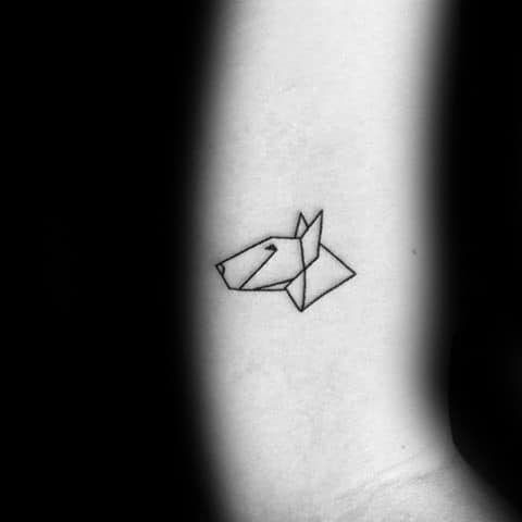 Minimalist origami-style dog tattoo on a forearm