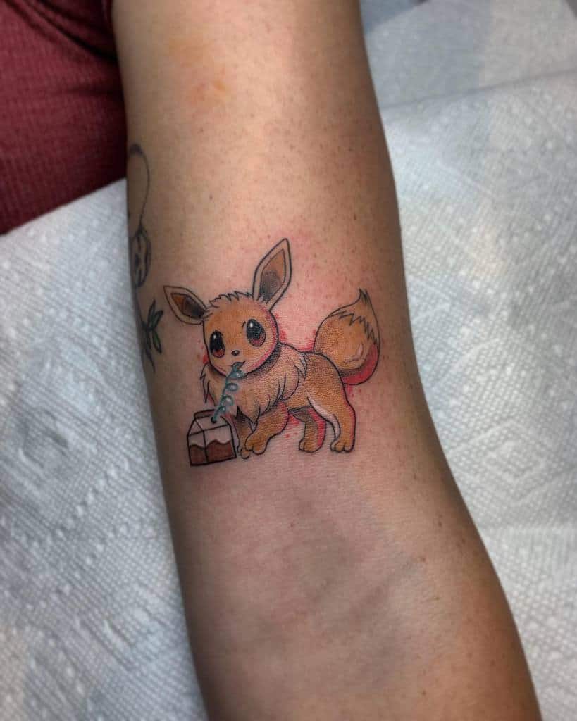 Playful Eevee tattoo sipping from a carton adds a whimsical and fun element to the design, making it a charming choice for a compact placement