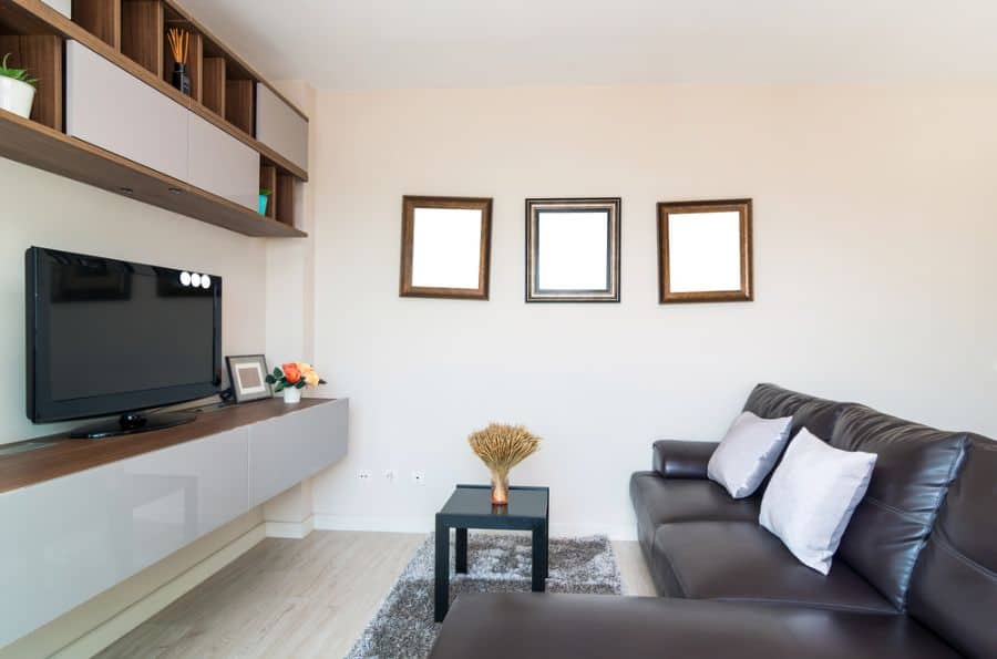 simple small living room black couch framed mirror wall art