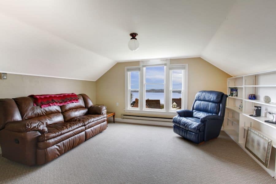 small attic living space leather couches white cabinet and shelves