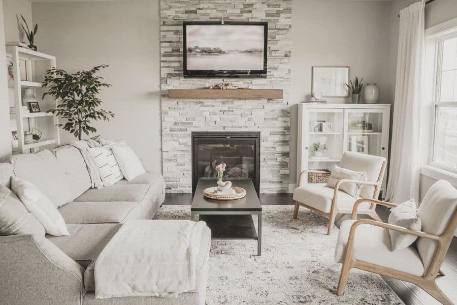 small gray living room stone fireplace gray couch white chairs 