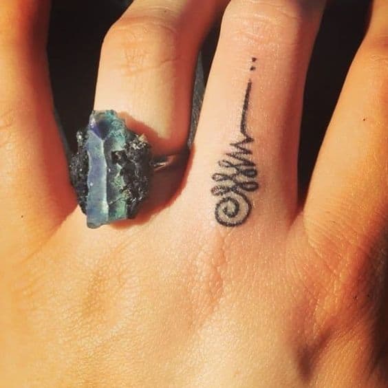 Bold Unalome tattoo on the finger, symbolizing the path to enlightenment, personal growth, and spiritual journey.