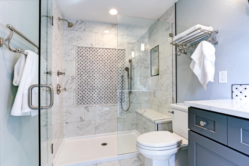 luxury bathroom with tile shower with bench seating