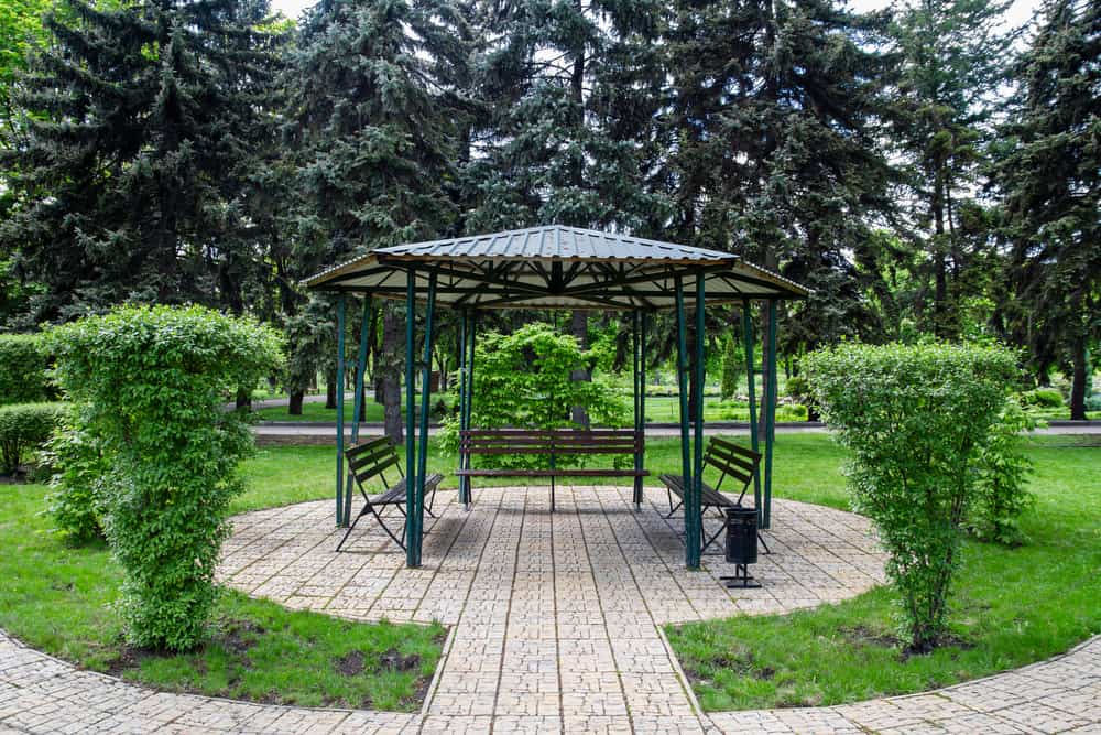 small green metal gazebo park bench style seating