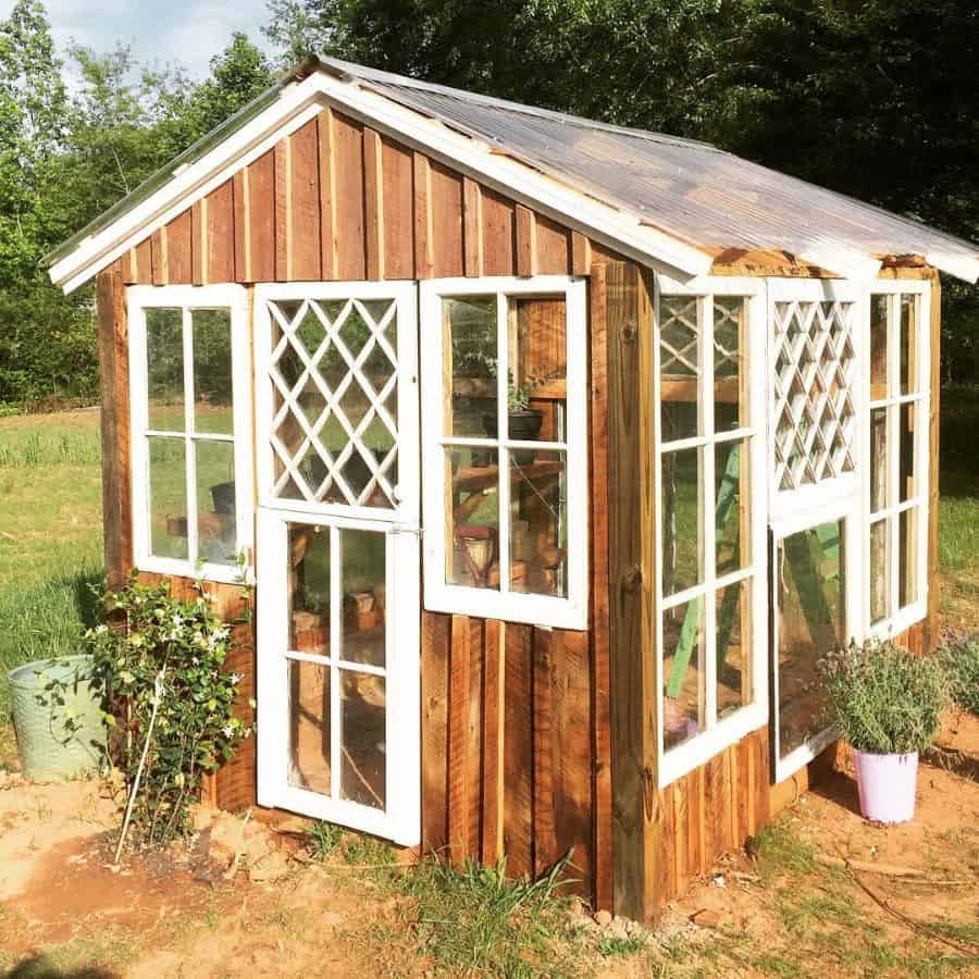 small wood greenhouse white window and door accents