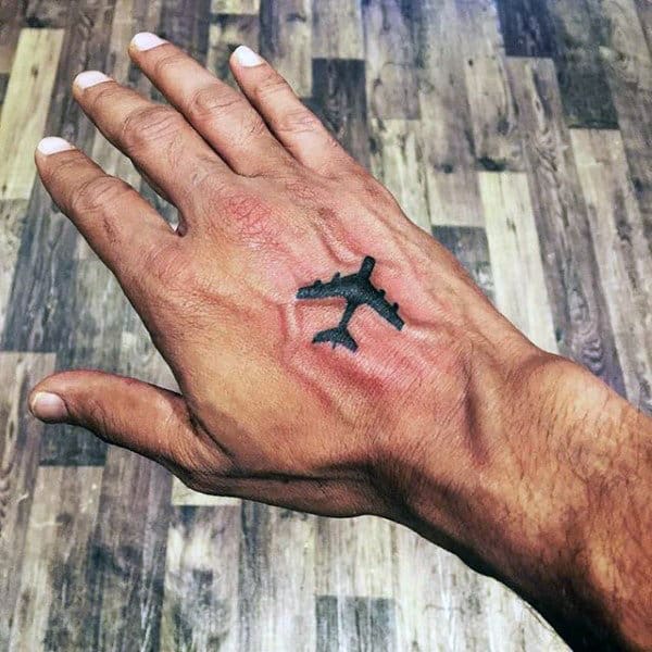 Small Guys Travel Tattoo Of Airplane On Hand With Black Ink