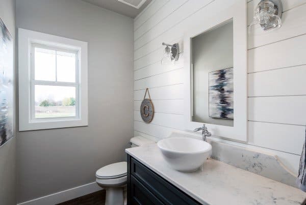 Half bath with bright shiplap walls, a round vessel sink, and a window beside the toilet, artwork adorns the wall
