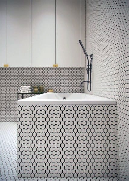 Bathtub with white hexagon honeycomb tiles covering walls and tub surround.