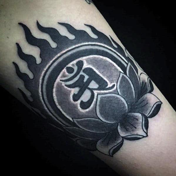 Bold black lotus flower tattoo with a central symbol and flame-like patterns on the inner arm for a striking look