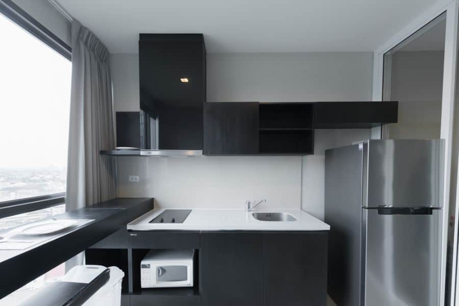 Small kitchen with black cabinets and white countertop.