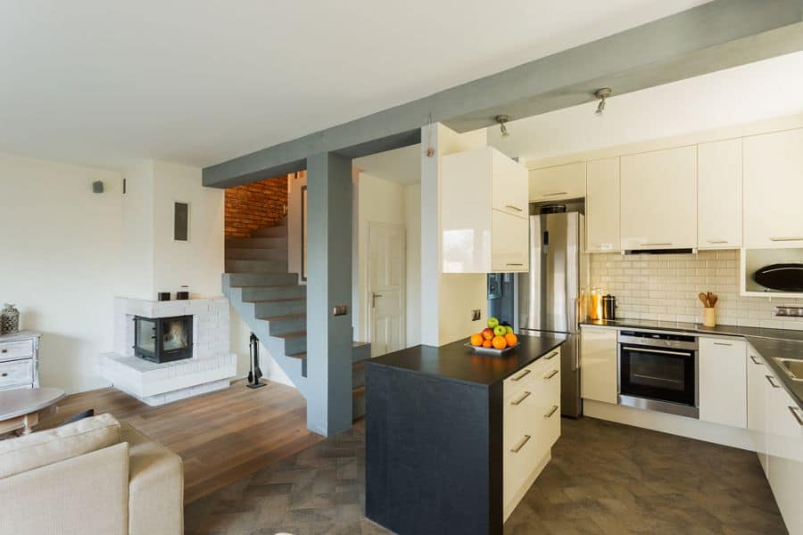 Kitchen with cream cabinets, black countertops, and stainless steel appliances.