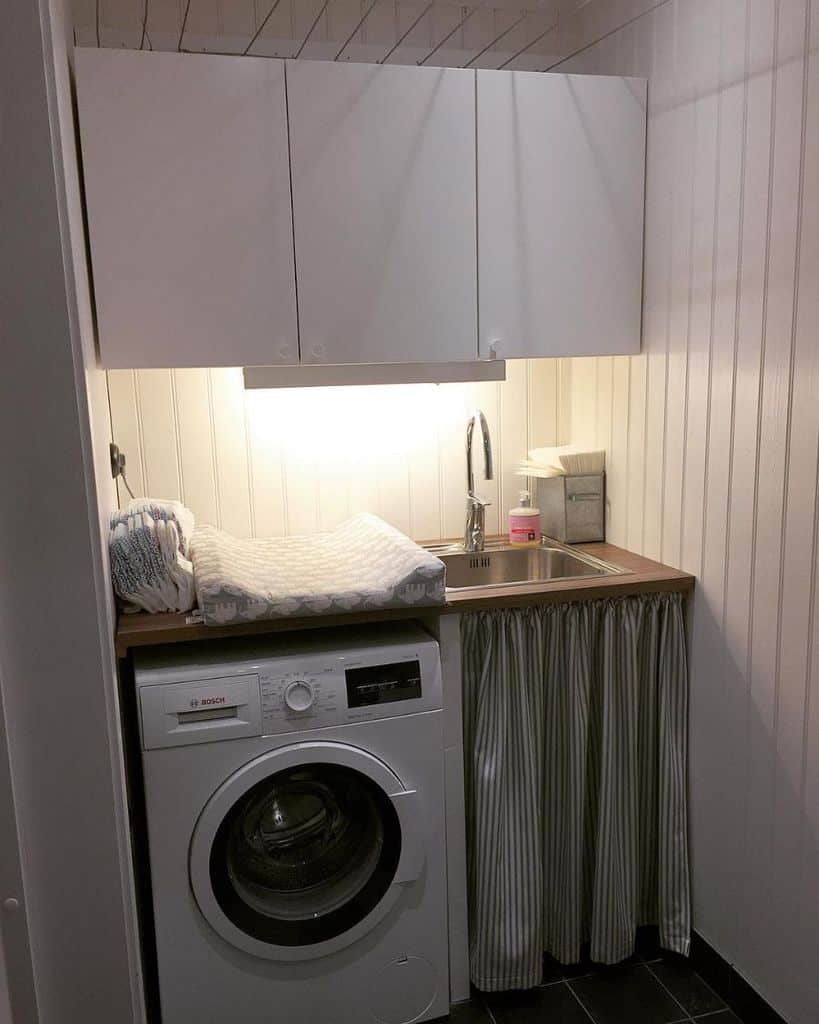 small laundry room with white cabinets