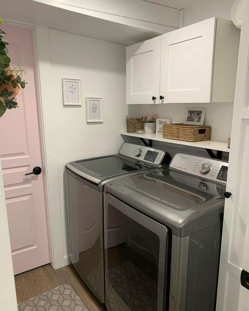 small white laundry room with pink door
