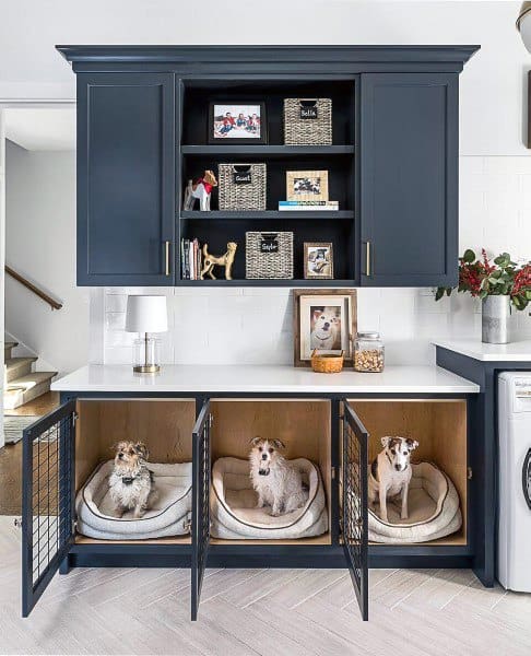 Laundry room with navy cabinets, built-in dog beds, and open shelving for decor and storage.