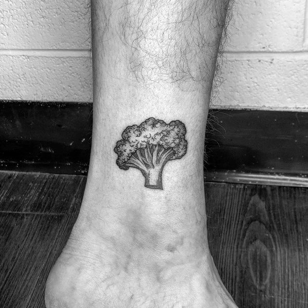 Small black ink broccoli tattoo on the ankle, featuring fine linework and shading for a minimalist yet detailed design.