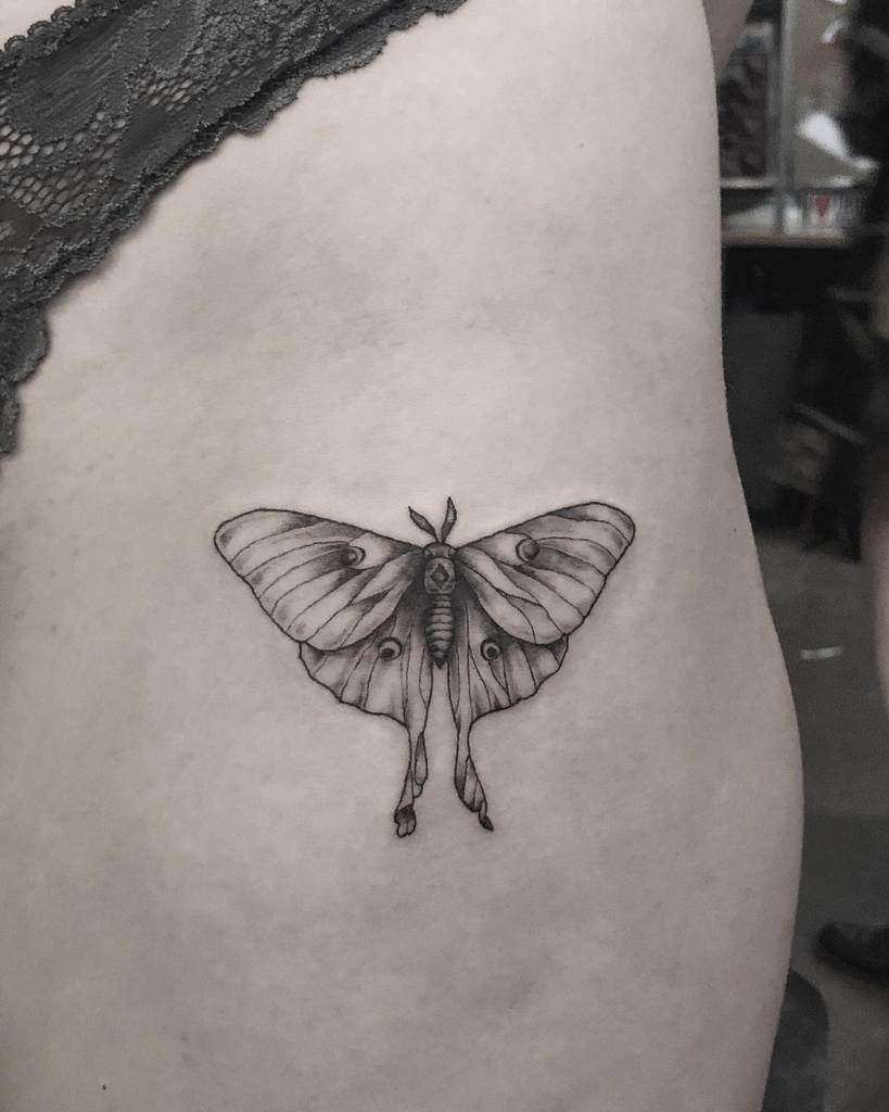 A black and grey Luna Moth tattoo with detailed wing patterns and shading