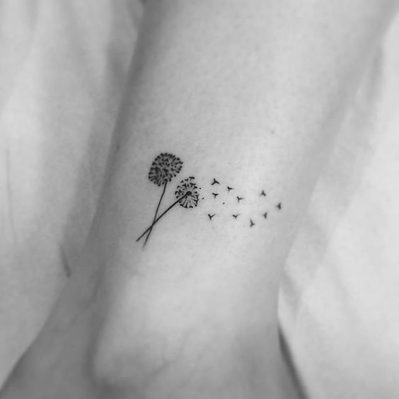This tattoo showcases two dandelions with seeds transforming into birds, representing change and freedom.