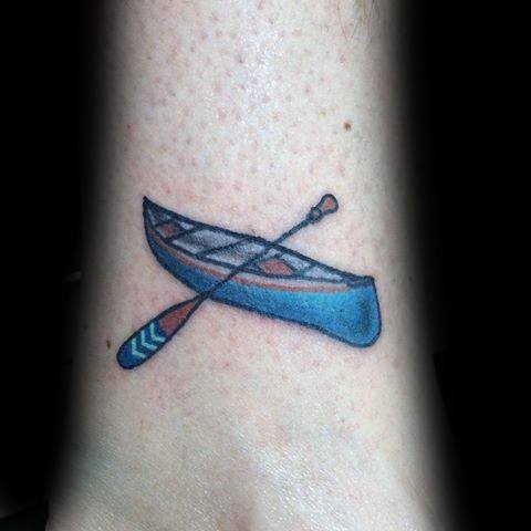 Alt text: Colorful tattoo of a blue canoe with a paddle, featuring clean lines and a playful, simple design.