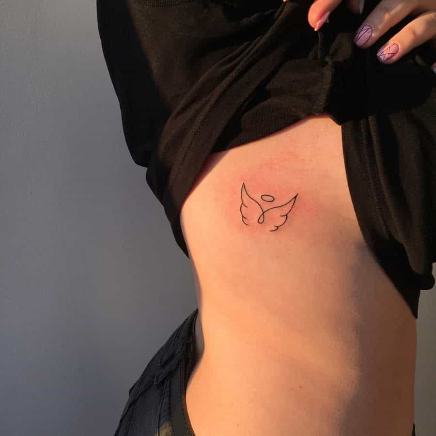 Minimalist angel wings tattoo featuring a simple line design with a halo for a delicate