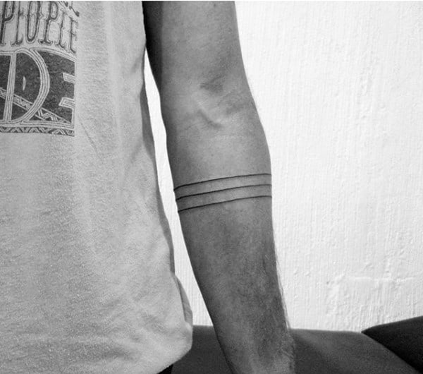 Arm with three dark, parallel bands tattooed around the forearm