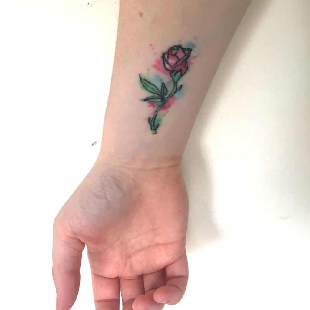 Tattoo of a rose with watercolor effect on a wrist