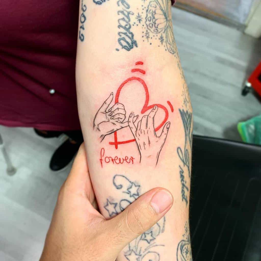 Tattoo of two hands making a pinky promise with a red heart outline, the word "forever" in cursive, and small motion lines