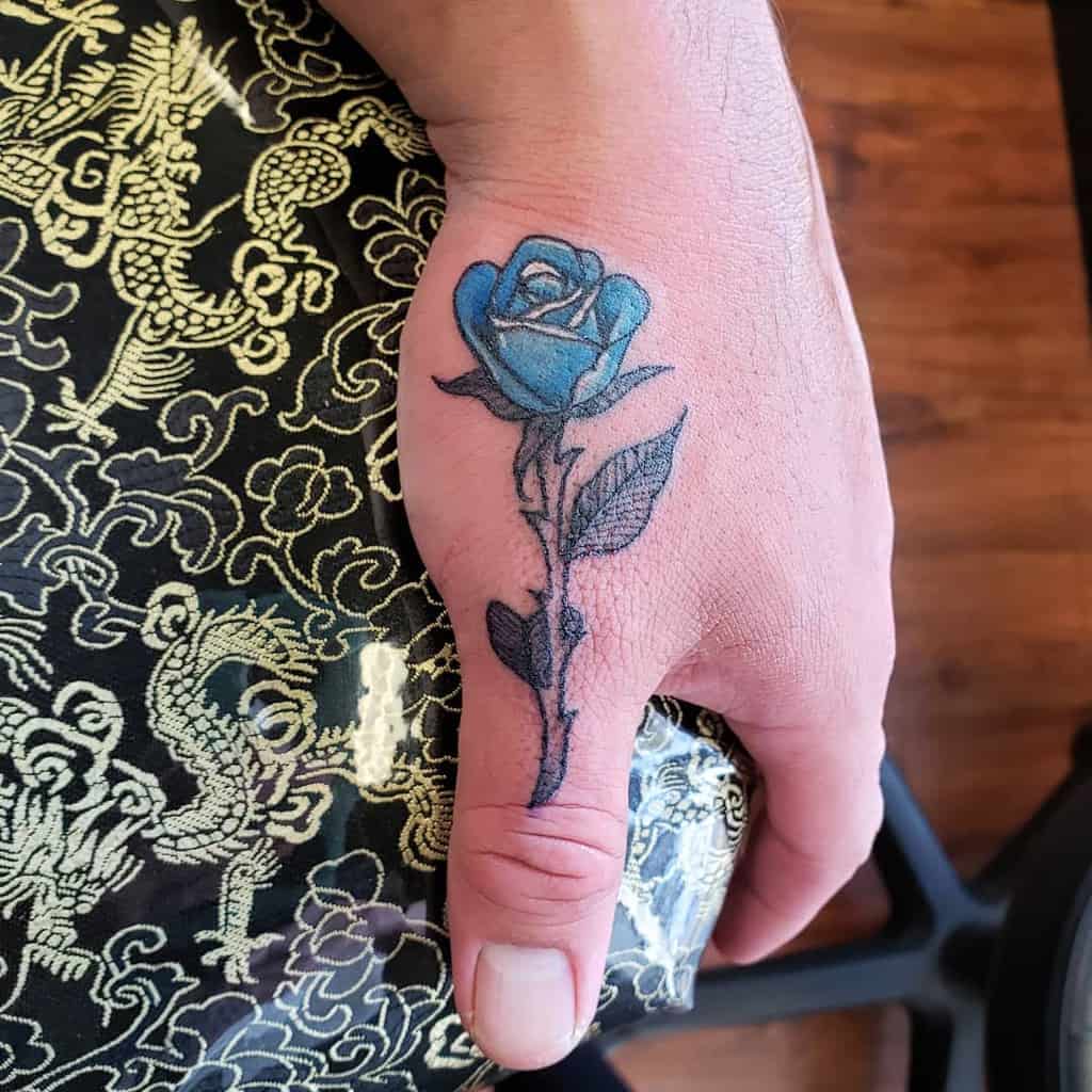 A stunning blue rose tattoo on the hand