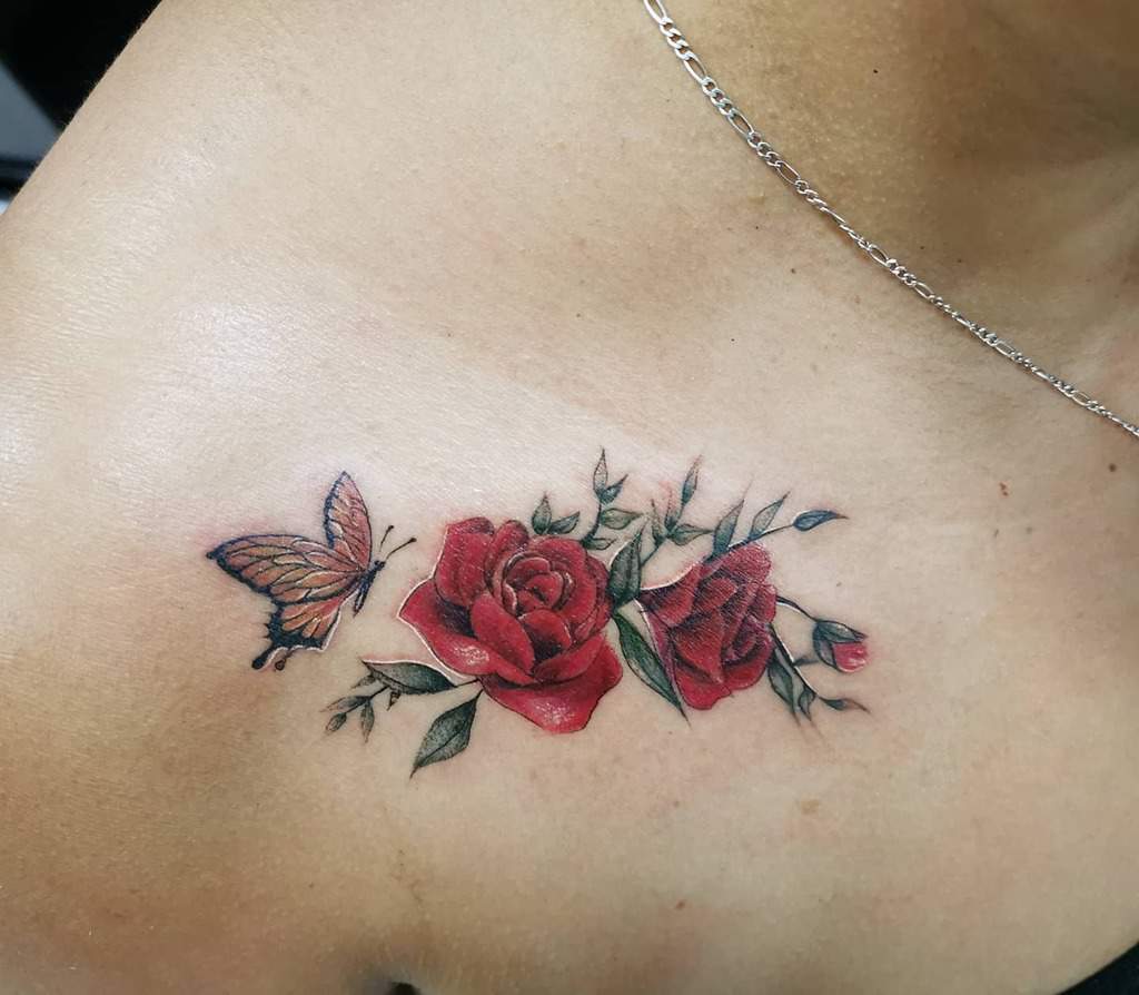 This beautifully detailed tattoo features vibrant red roses and a delicate butterfly, creating an elegant and symbolic design perfect for the collarbone area