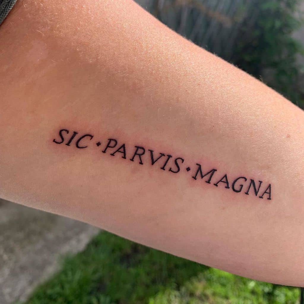 Tattoo on an arm reads "SIC PARVIS MAGNA" in black ink