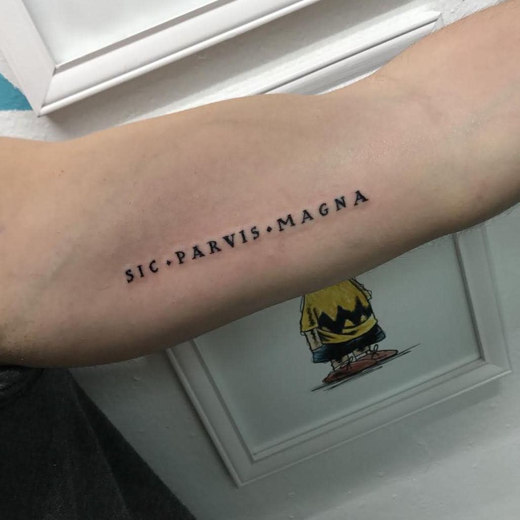 Tattoo on an arm reading "SIC · PARVIS · MAGNA"