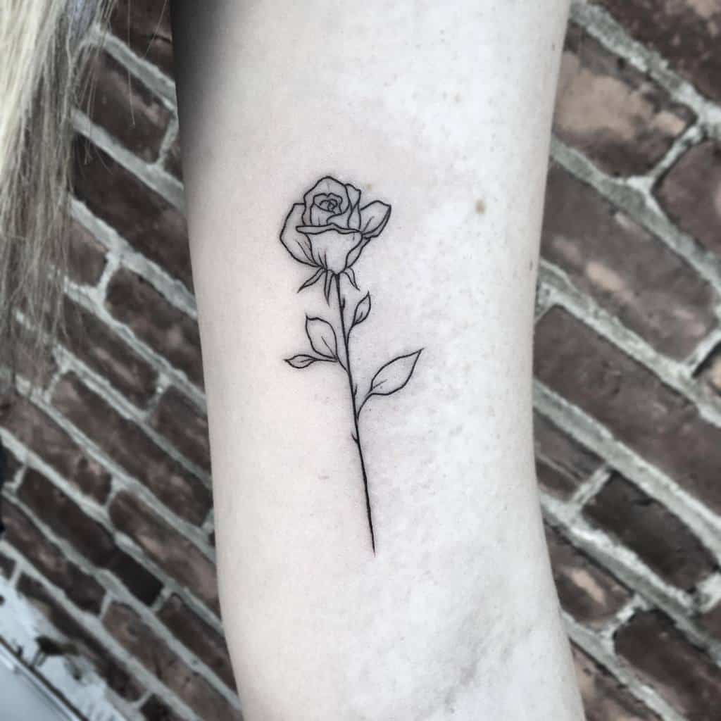 Line art rose tattoo on forearm