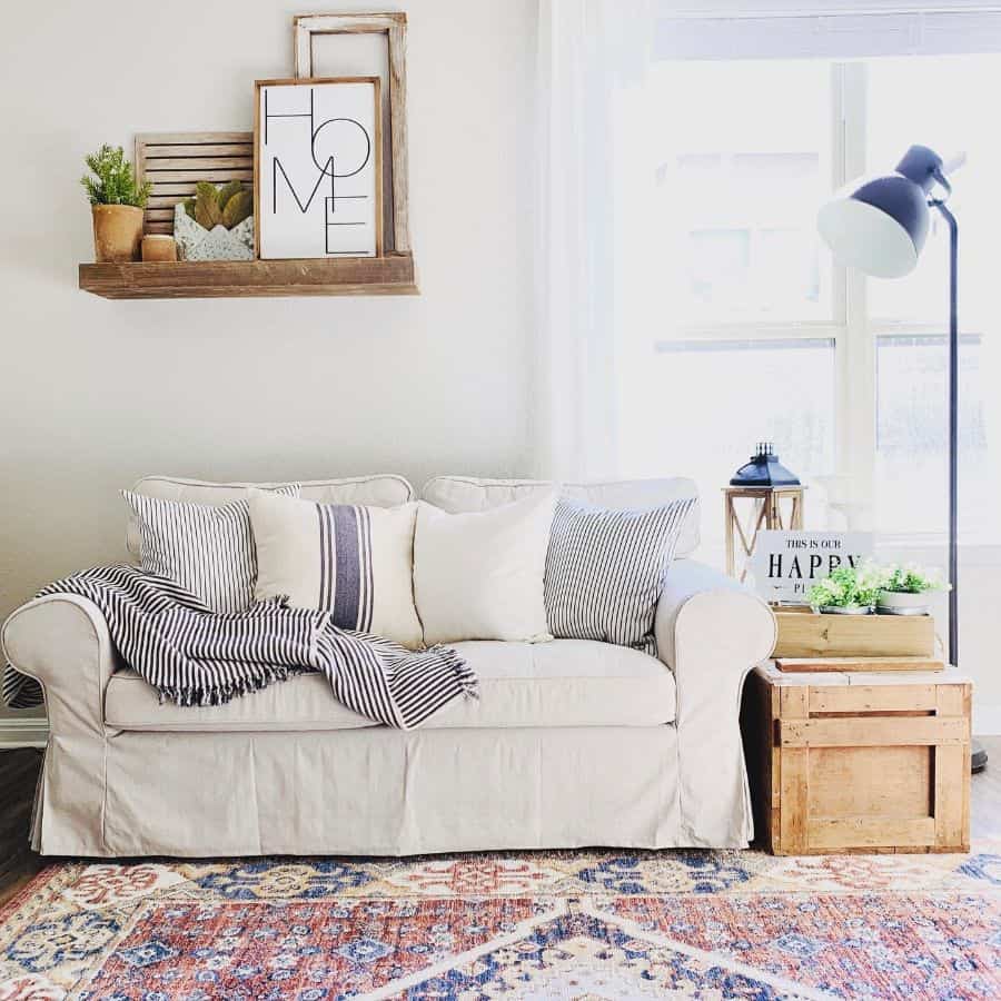 simple small living room white and blue sofa blue floor lamp wood wall shelf pattern floor rug