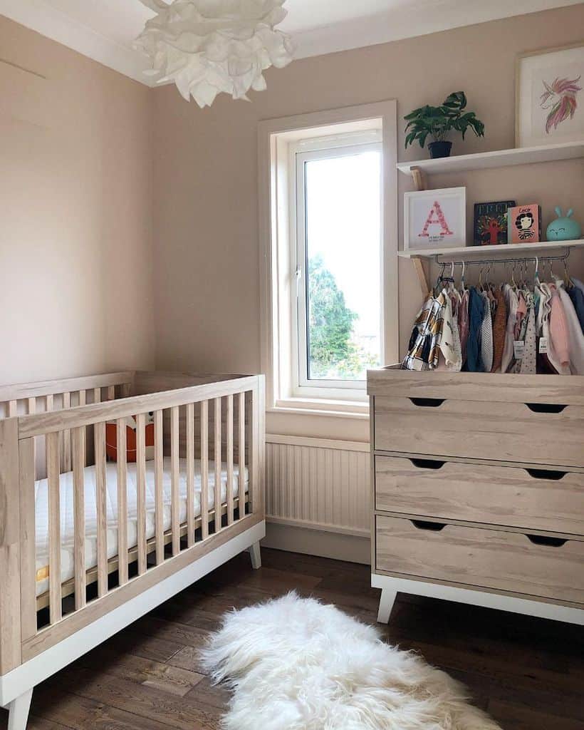 small simple nursery wood crib wardrobe with drawers wall shelves white floor rug