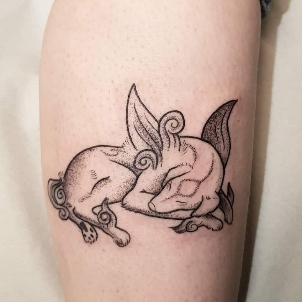 Minimalist Okami tattoo of a sleeping wolf with delicate swirling details and soft shading, capturing a serene and mystical look