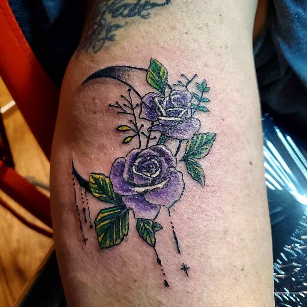 Tattoo of purple roses with a crescent moon on an arm