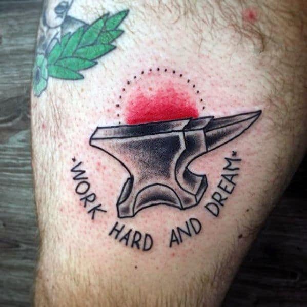 Anvil tattoo with a red sunburst and dotted halo above, paired with the motivational phrase “Work Hard and Dream” curved underneath.