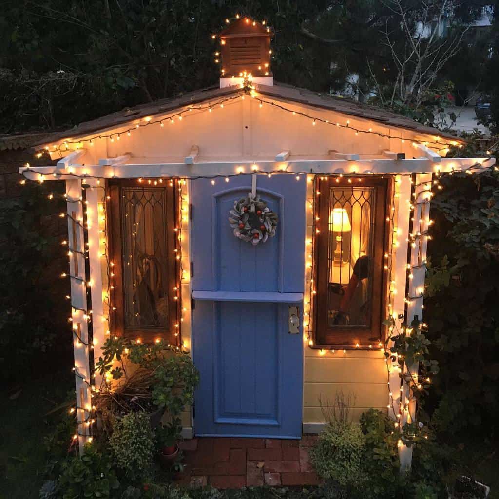 she shed with blue door and fairy lights 
