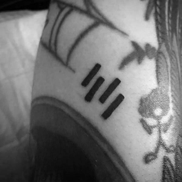 Minimalist version of the Black Flag bars tattooed in a compact, slanted layout, blending punk influence with subtle ink placement.