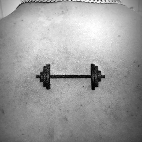 Minimalist black barbell tattoo on the upper back, symbolizing strength, fitness dedication, and a passion for weightlifting or CrossFit.