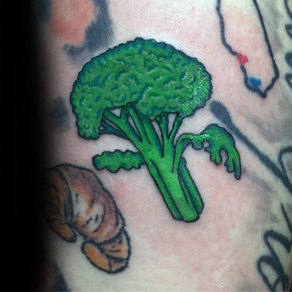Bright green broccoli tattoo with bold outlines and smooth shading, creating a vibrant and playful design on the skin.